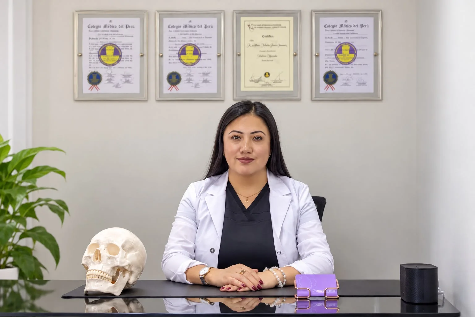 Dra. Alytsa Garcia en su escritorio frente a sus diplomas del Colegio Médico del Perú
